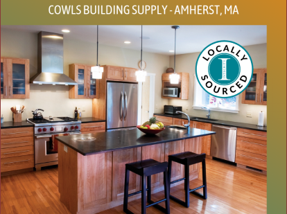 Bright contemporary kitchen showcasing oak cabinets, granite center island, stainless fridge and dishwasher, hanging pendant lamps, and Cowls Building Supply branding with local sourcing emblem