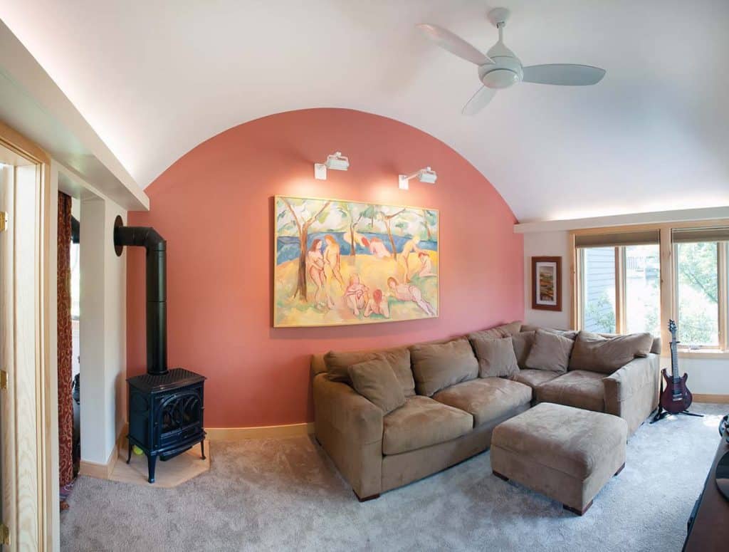 Interior photograph of a family room and bathroom renovation featuring a barrel-vault ceiling and uplighting completed by Integrity Development & Construction in Amherst, MA.