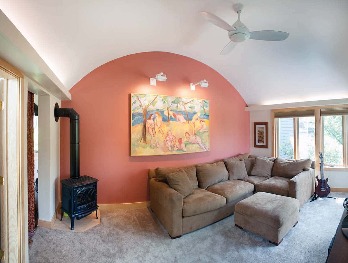Interior photograph of a family room and bathroom renovation featuring a barrel-vault ceiling and uplighting completed by Integrity Development & Construction in Amherst, MA.